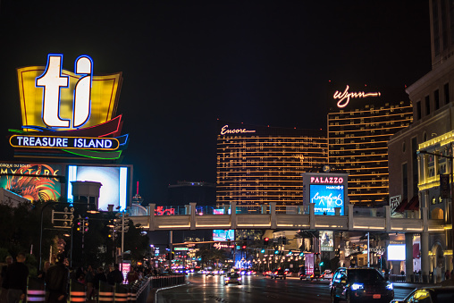 Las Vegas, NV / USA - March 8, 2017: Night view of the bright lights on Las Vegas Boulevard, with the sign for the TI (Treasure Island) hotel and casino high above. Encore and Wynn hotels behind.