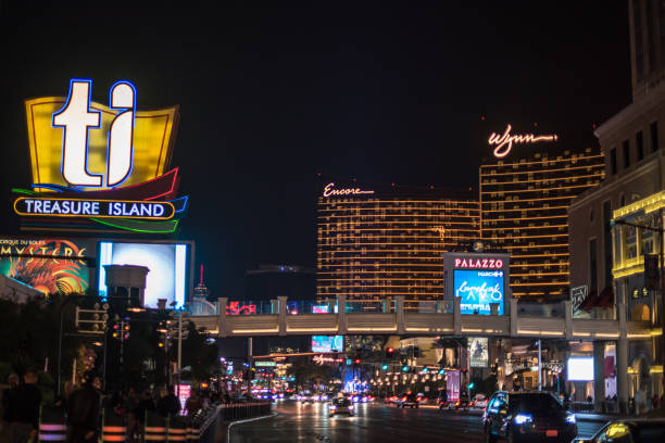 Nighttime street scene in Las Vegas Las Vegas, NV / USA - March 8, 2017: Night view of the bright lights on Las Vegas Boulevard, with the sign for the TI (Treasure Island) hotel and casino high above. Encore and Wynn hotels behind. wynn las vegas stock pictures, royalty-free photos & images