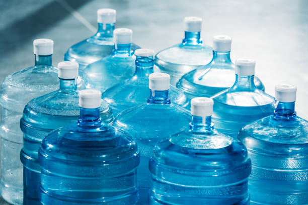 istock Plastic large blue water bottles on floor 942672842