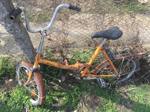 istock The lonely old bicycle with an orange frame in a grass, rusts at a fence. 942678930