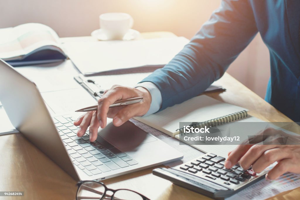 businessman working in office with using calculator and laptop. concept finance and accounting Financial Advisor Stock Photo