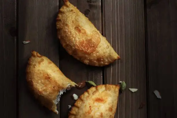 Homemade Gujiya / Karanji - Indian festival sweet on dark moody background