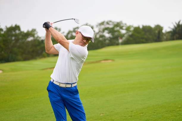 istock Asian man swinging club in golf course in summer 942685856