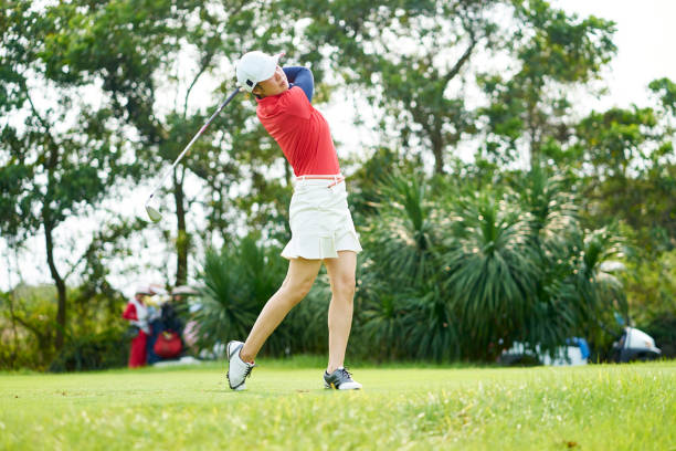 istock Asian beauty swinging a golf club in course 942686494