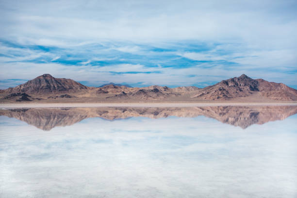 Crystal clear water of Bonneville Salt Flats, USA. Crystal clear water with mountains and blue, cloudy sky. Bonneville Salt Flats, Tooele County, Utah, United States. tooele stock pictures, royalty-free photos & images