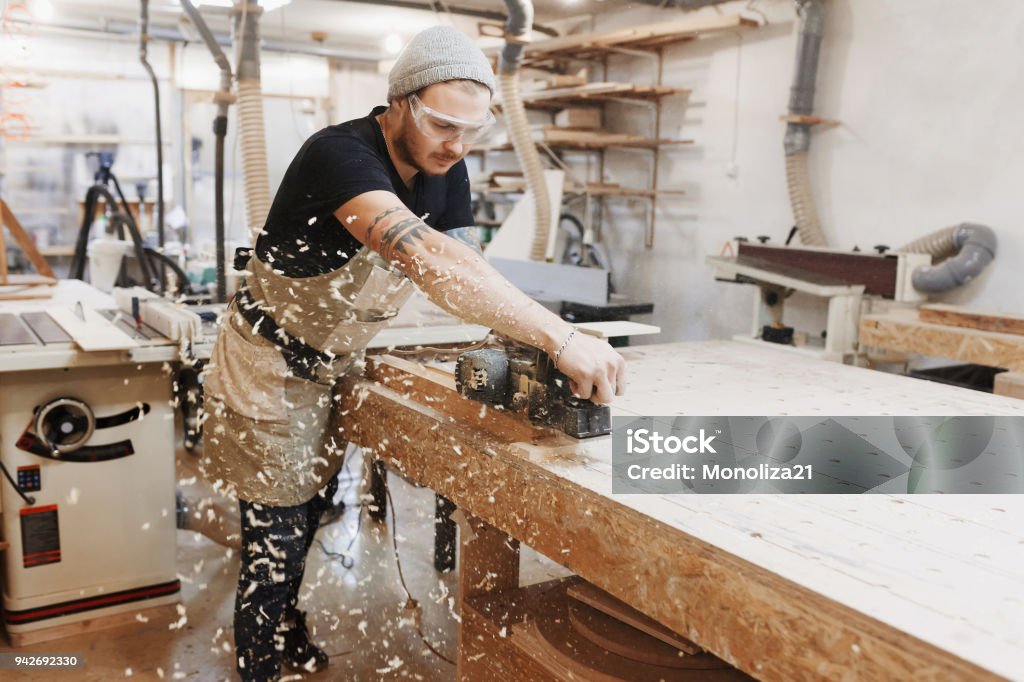 Tischler arbeiten mit elektrischen Hobel auf Holzbrett in Werkstatt. Handwerker macht eigenen erfolgreichen Kleinunternehmen. - Lizenzfrei Schreiner Stock-Foto