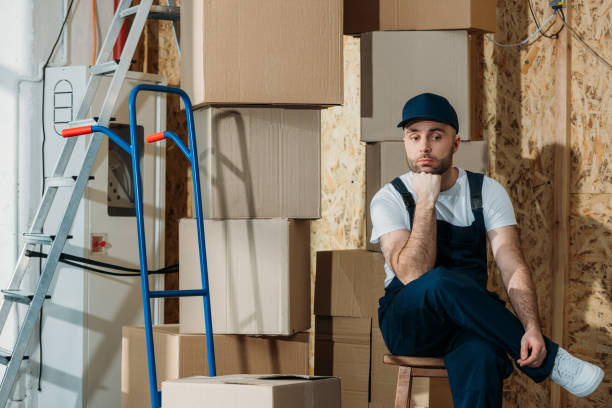 istock Bored delivery man waiting by stacks of boxes 942692336