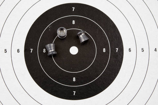 istock Pneumatic weapons on the shooting range. Shooting accessories on a wooden table. Dark background. 942692592