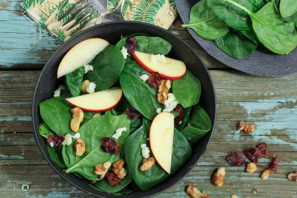istock Spinach Apple salad served in a black bowl, selective focus 942693610