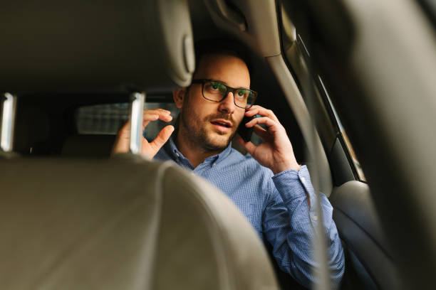 istock Businessman using mobile phone in the car 942699546
