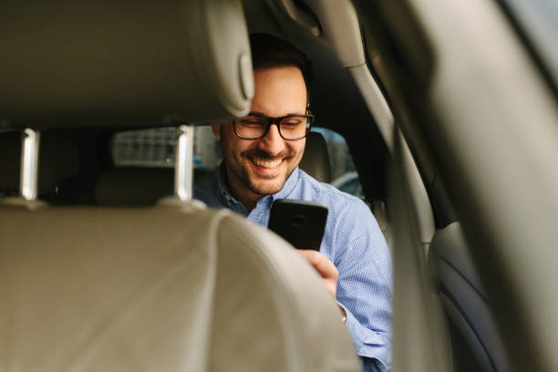 istock Businessman using mobile phone in the car 942699548