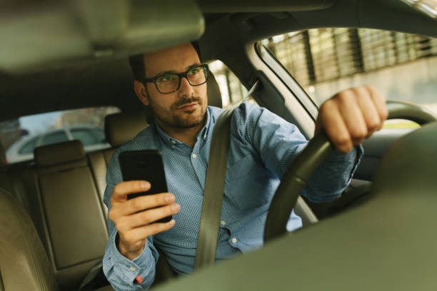 istock Businessman using mobile phone in the car. Reckless driving 942699712