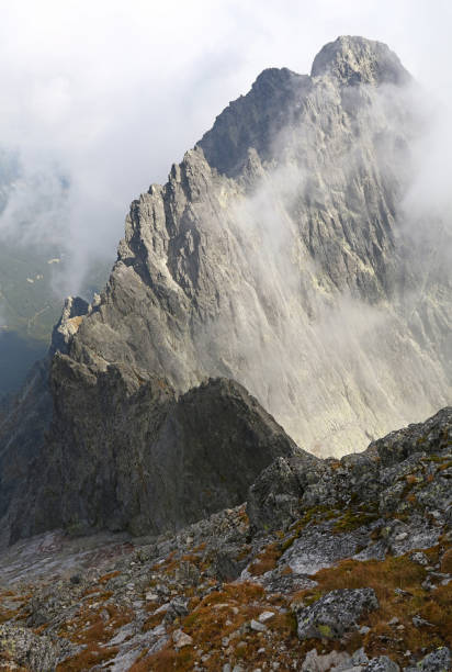 istock Rocky mountain ridge in foggy clouds 942700166
