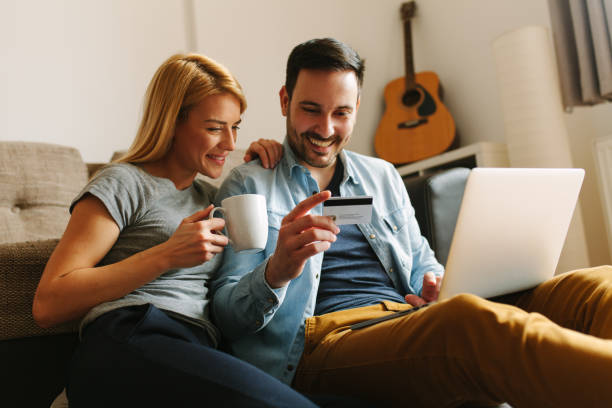 happy couple relaxed at home, doing some online shopping - internet e mail paying credit card imagens e fotografias de stock