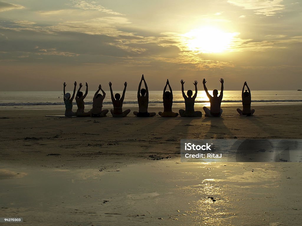 Aula de ioga ao pôr do sol do oceano - Foto de stock de Praia royalty-free