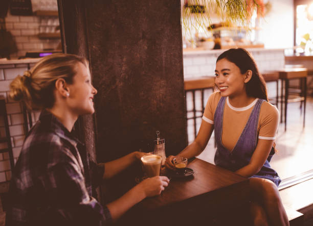 istock Young multi-ethnic female friends drinking coffee at hipster cafe 942703698