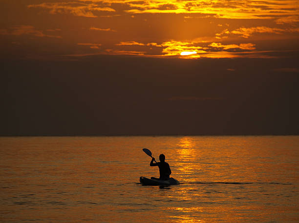 istock Silhouette of man kayaking at sunset 94270402