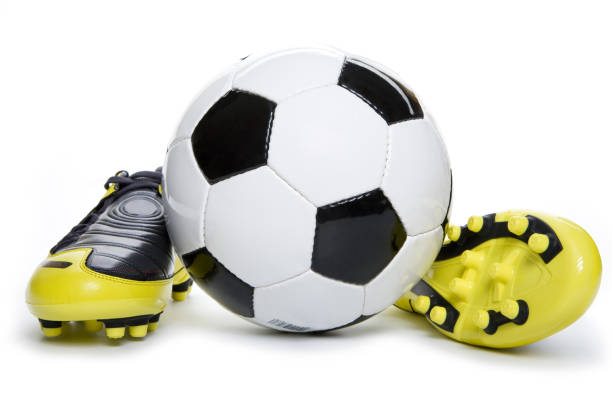 old vintage damaged futsal sports shoes and ragged yellow ball on white background football  object isolated