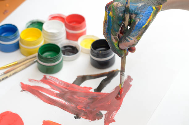 istock A child's hand in paint paints gouache on white paper. 942715636