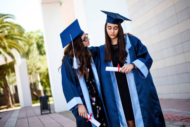 istock Two unhappy girlfriends left after graduation 942720994