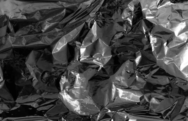 istock Light and shadows shaped by old crumpled metal foil 942724382