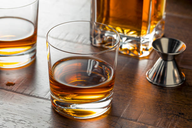 delizioso whisky bourbon pulito - whisky alcohol pouring glass foto e immagini stock