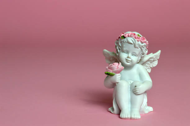 istock Cherub figurine on pink background 942744368