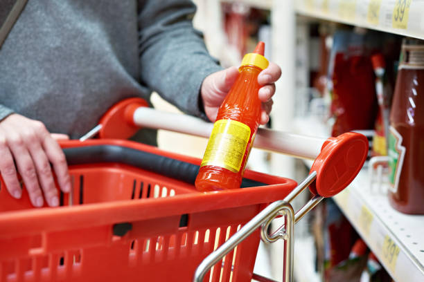 istock Hot chilli sauce in hand at grocery store 942747518