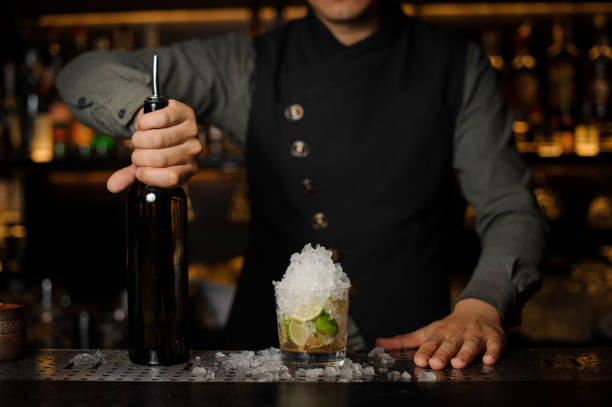 istock Barman holding a bottle of cachaca for making Caipirinha cocktail 942747882