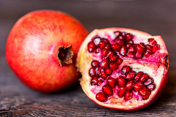 istock Ripe pomegranate fruits on wooden background 942747962
