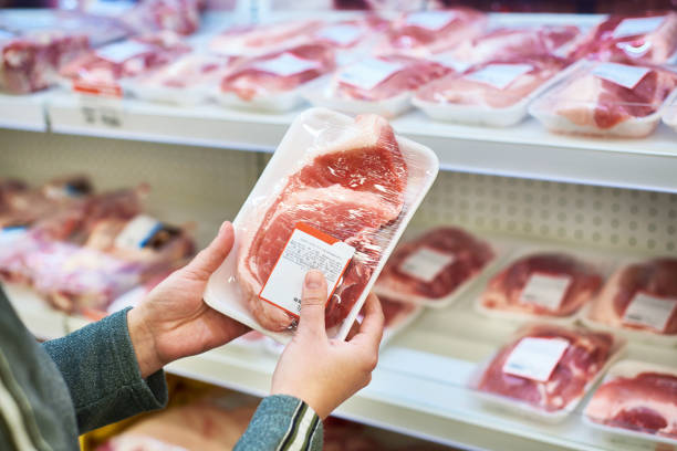 식료품에서 돼지 고기 구매자 손에 - supermarket meat women packaging 뉴스 사진 이미지