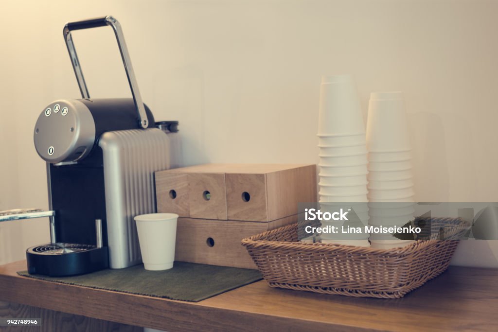 Everyday Things Capsule Coffee Machine Stand On Wooden Table Next To White  Paper Cup Folding Stack In Wicker Basket Toned With Warm Instagram Filters  Stock Photo - Download Image Now - iStock