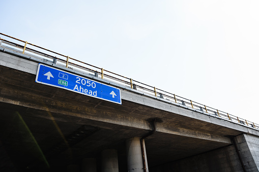 A low angle view of a blue traffic road sign with the message \