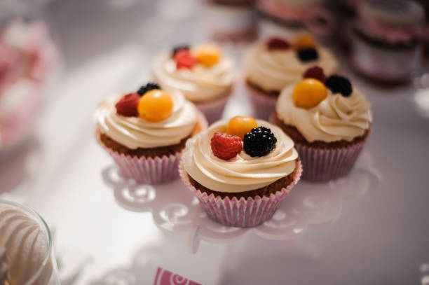 istock Tasty cupcakes with cream decorated with berries 942756020