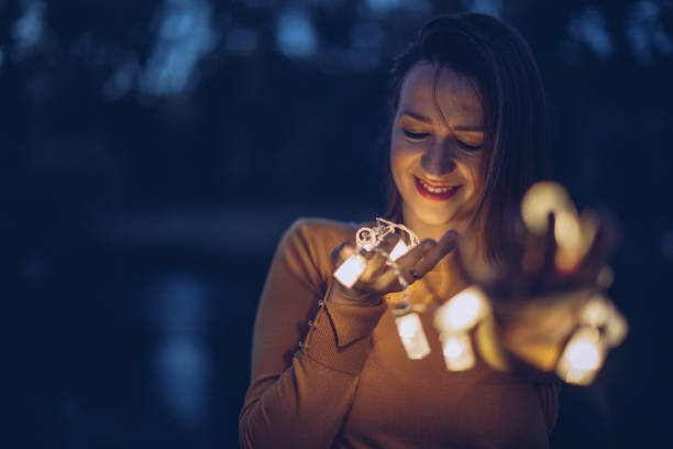istock Pretty young woman holding lights 942756072