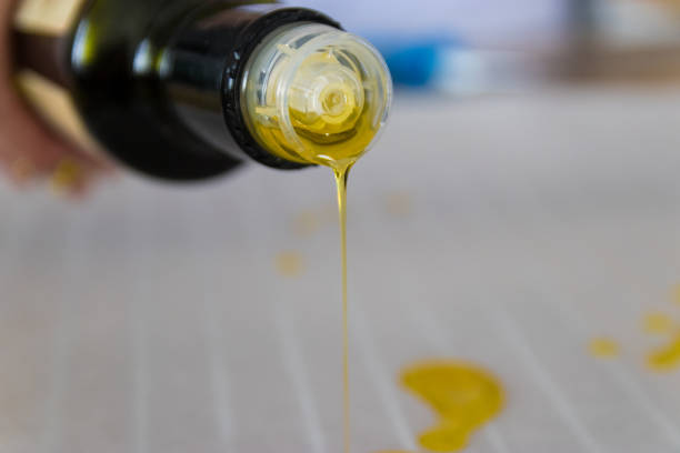 istock Olive oil pouring from the bottle on baking paper 942760214