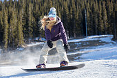 Active woman snowboarding at mountain resort