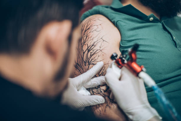 istock Artist drawing tattoo on man's hand 942768596