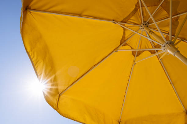 istock Yellow umbrella and rays of sun 942773764