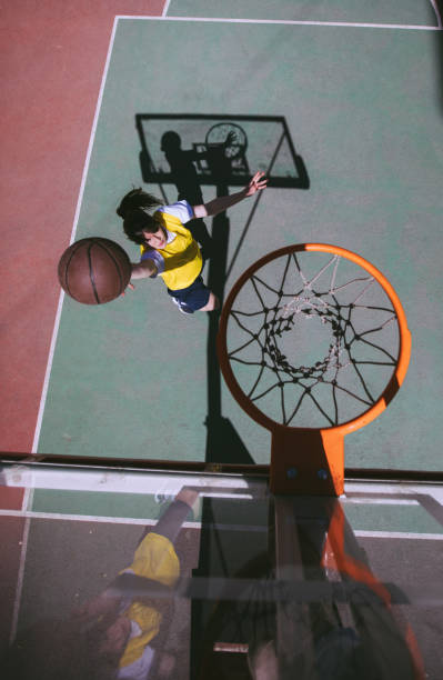istock Young woman playing basketball 942781078