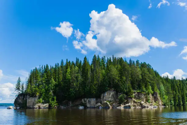 The forested cliff on the river bank, blue sky