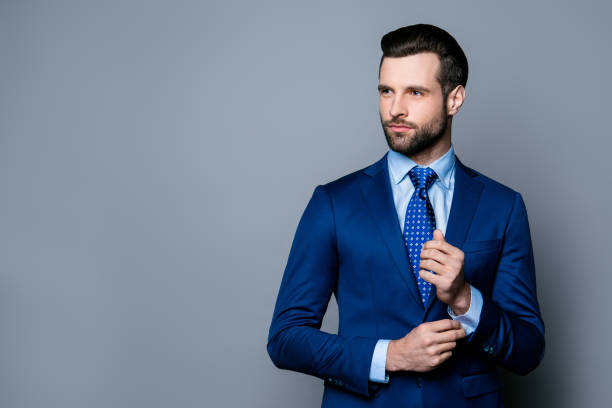 porträt von ernst modisch gut aussehender mann in blauem anzug und krawatte knöpfte manschettenknöpfe - shirt necktie men businessman stock-fotos und bilder