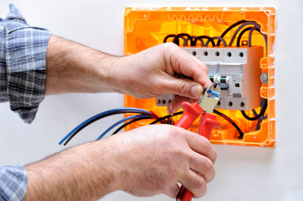 Electrician technician at work on a residential electric panel Electrician technician working on a residential electric panel, cuts the cable with a cable cutter cable tester stock pictures, royalty-free photos & images