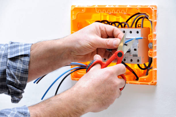 Electrician technician at work on a residential electric panel Electrician technician at work on a residential electrical panel, prepares the cable with professional scissors cable tester stock pictures, royalty-free photos & images