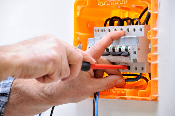 Electrician technician at work on a residential electric panel Electrician technician working on a residential electrical panel, fixing with a screwdriver the cable in the magnetothermal switch cable tester stock pictures, royalty-free photos & images