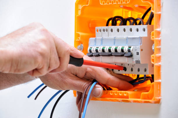 Electrician technician at work on a residential electric panel Electrician technician working on a residential electrical panel, fixing with a screwdriver the cable in the magnetothermal switch cable tester stock pictures, royalty-free photos & images