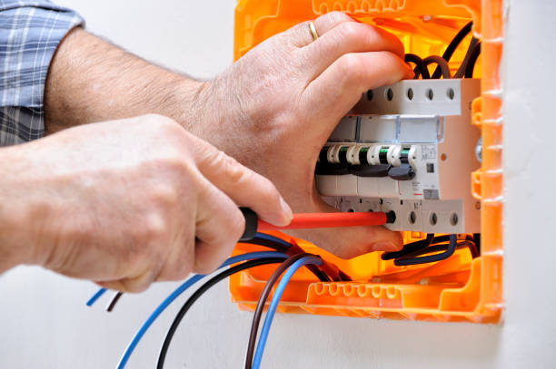 Electrician technician at work on a residential electric panel Electrician technician working on a residential electrical panel, fixing with a screwdriver the cable in the magnetothermal switch cable tester stock pictures, royalty-free photos & images