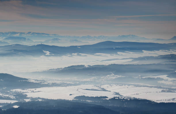 istock Blue mountain ridges and snowfields in hazy valleys in Slovakia 942806286