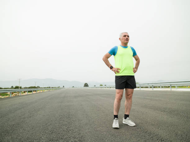 istock Mature Adult Man Getting Ready For Running On Asphalt Road 942806308