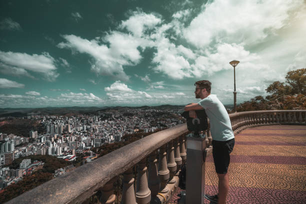Bearded man in sunglasses is looking at cityscape